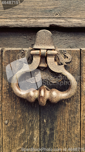 Image of Vintage doorknocker on weathered wooden door background