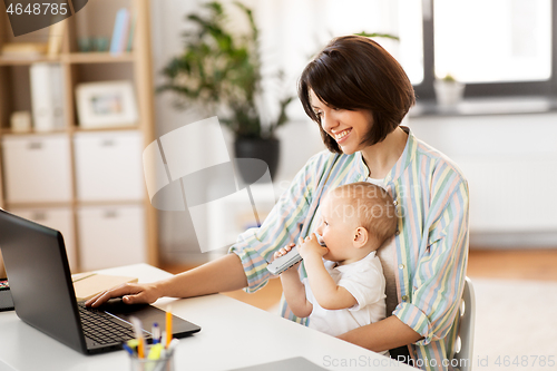 Image of working mother with baby boy and laptop at home