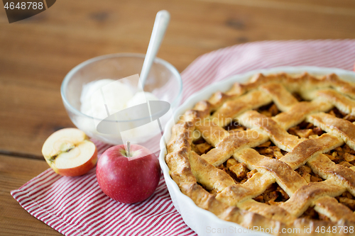 Image of apple pie with ice cream on wooden table