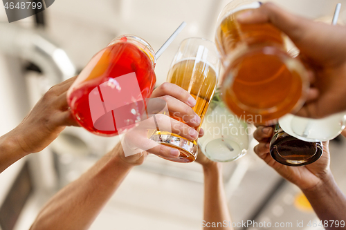 Image of friends clinking glasses at bar or restaurant