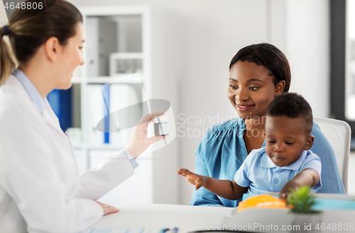 Image of doctor giving medicine to woman with son at clinic