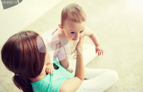 Image of happy young mother with little baby at home