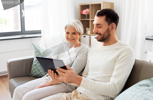 Image of old mother and adult son with tablet pc at home