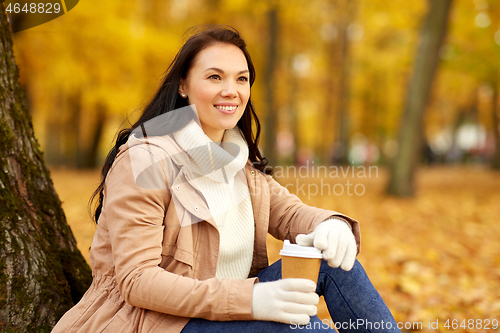 Image of woman drinking takeaway coffee in autumn park