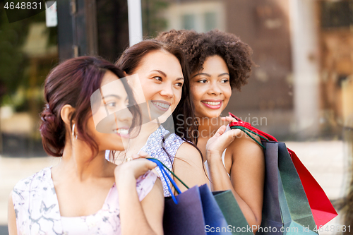 Image of happy women with shopping bags in city