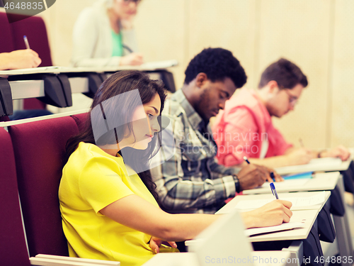 Image of group of students with notebooks in lecture hall