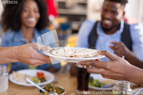 Image of international friends eating at restaurant