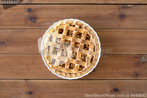 Image of close up of apple pie in mold on wooden table