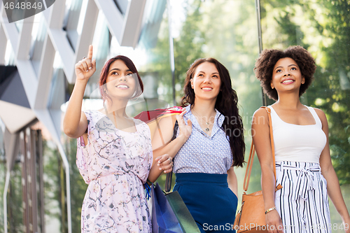 Image of happy women with shopping bags in city