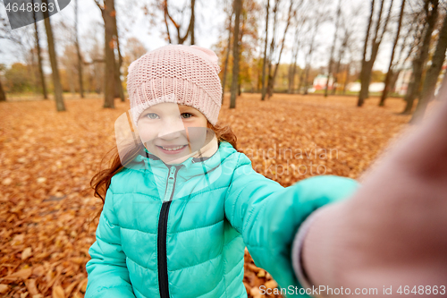 Image of happy girl taking selfie at autumn park