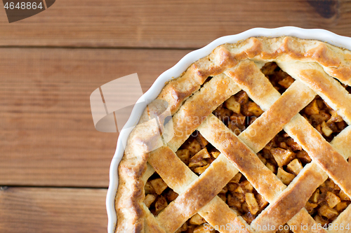 Image of close up of apple pie in mold on wooden table