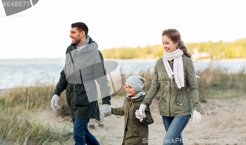 Image of happy family walking along autumn beach