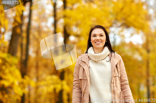 Image of beautiful happy young woman smiling in autumn park