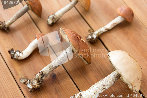 Image of brown cap boletus mushrooms on wooden background