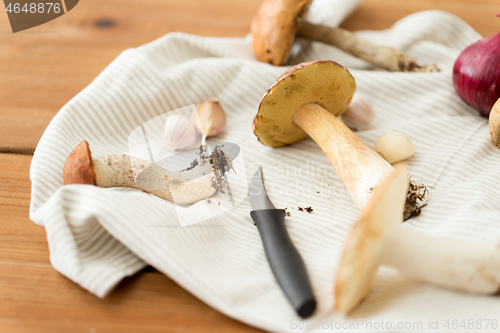 Image of edible mushrooms, kitchen knife and towel