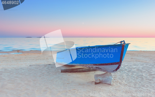 Image of Pink Sunset Seascape With A Blue Fishing Boat On A Beach