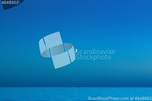 Image of Blue Night Sky With A Crescent Moon Over The Sea