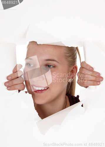 Image of Beautiful face of woman peeking trough a hole