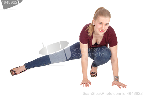 Image of Slim young woman crouching on floor