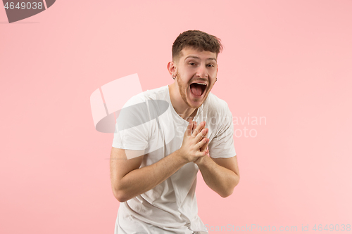 Image of The happy business man standing and smiling against pink background.