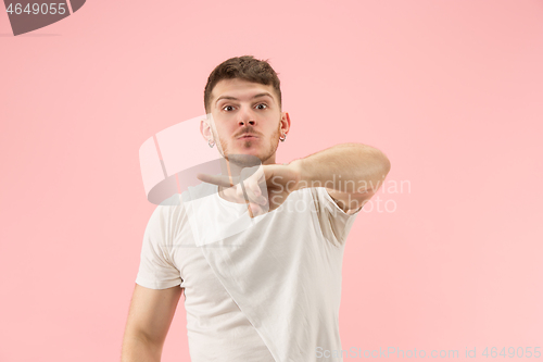 Image of Beautiful male half-length portrait isolated on pink studio backgroud. The young emotional surprised man