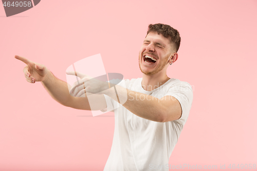 Image of The happy business man standing and smiling against pink background.