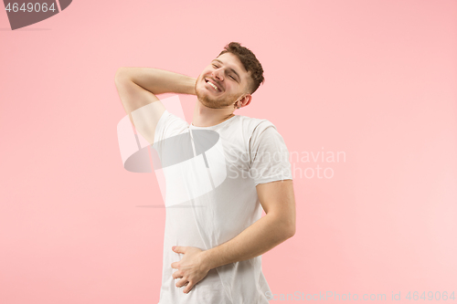 Image of The happy businessman standing and smiling against pink background.