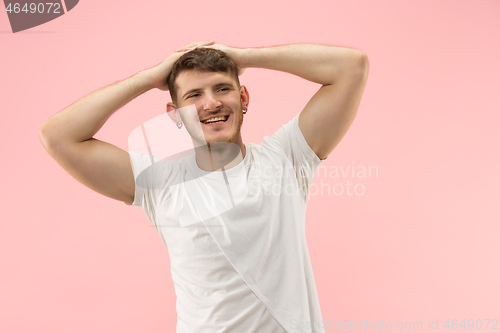 Image of The happy businessman standing and smiling against pink background.