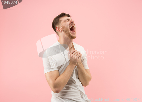 Image of The happy business man standing and smiling against pink background.