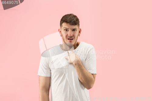 Image of Beautiful male half-length portrait isolated on pink studio backgroud. The young emotional surprised man