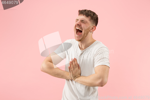 Image of The happy business man standing and smiling against pink background.