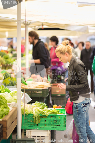 Image of Woman buying vegetable at local food market.