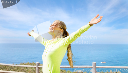 Image of happy woman in sports clothes at seaside