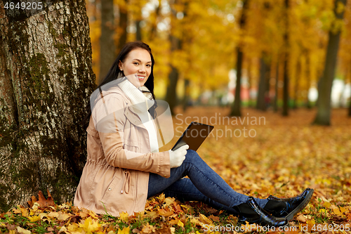 Image of woman with tablet computer at autumn park