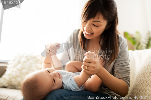 Image of happy young mother with little baby son at home