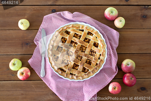 Image of close up of apple pie in baking mold and knife