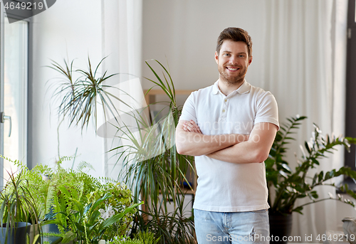 Image of smiling man with houseplants at home