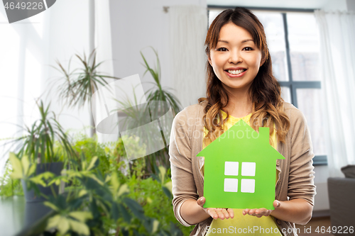 Image of happy asian woman with green house at home