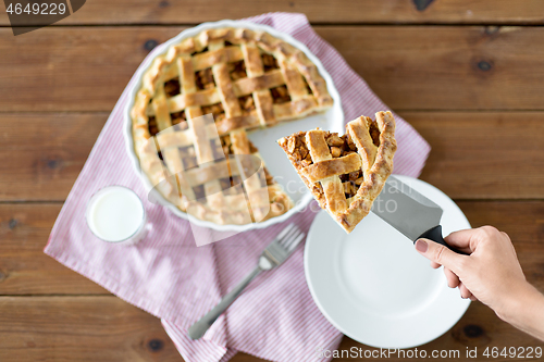 Image of close up of hand with piece of apple pie on knife