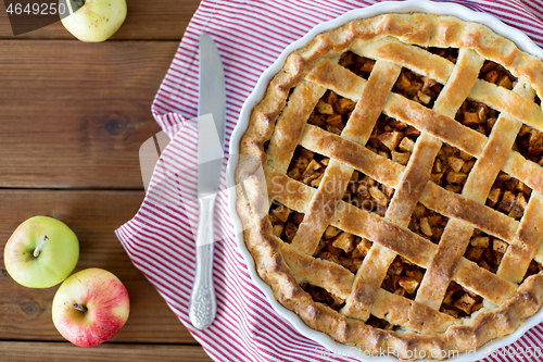 Image of close up of apple pie in baking mold and knife