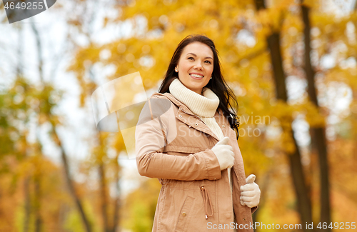 Image of beautiful happy young woman smiling in autumn park