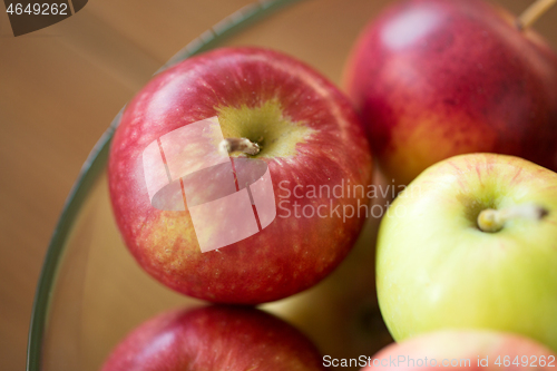 Image of ripe apples in glass bowl on wooden table