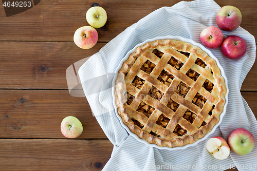 Image of apple pie in baking mold on wooden table