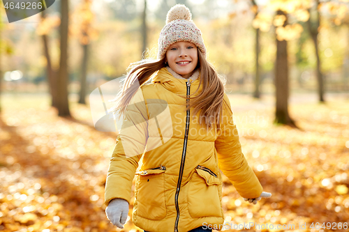 Image of happy girl walking at autumn park