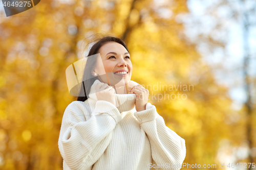 Image of portrait of happy young woman in autumn park