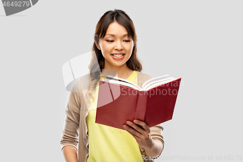 Image of happy asian woman reading book