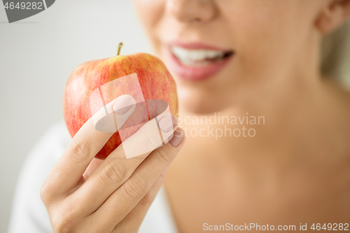 Image of close up of woman holding ripe red apple