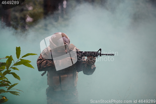 Image of soldier in action aiming  on weapon  laser sight optics