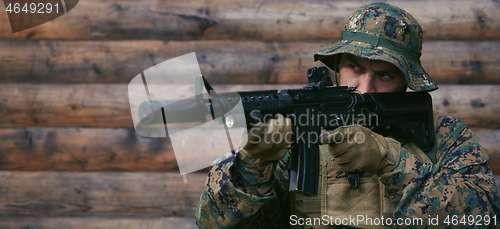 Image of soldier in action aiming  on weapon  laser sight optics