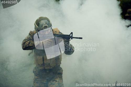 Image of soldier in action aiming  on weapon  laser sight optics